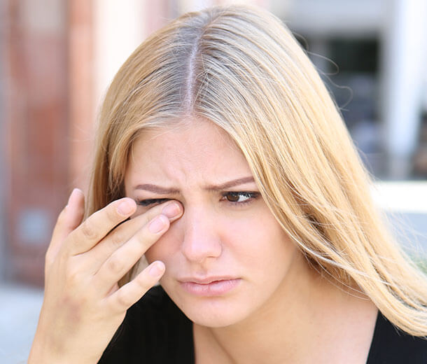 Blond woman wiping her eye with her finger