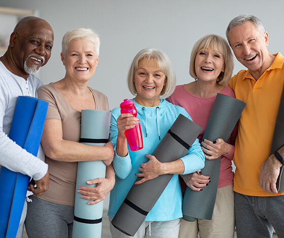 Group of friends holding yoga mats