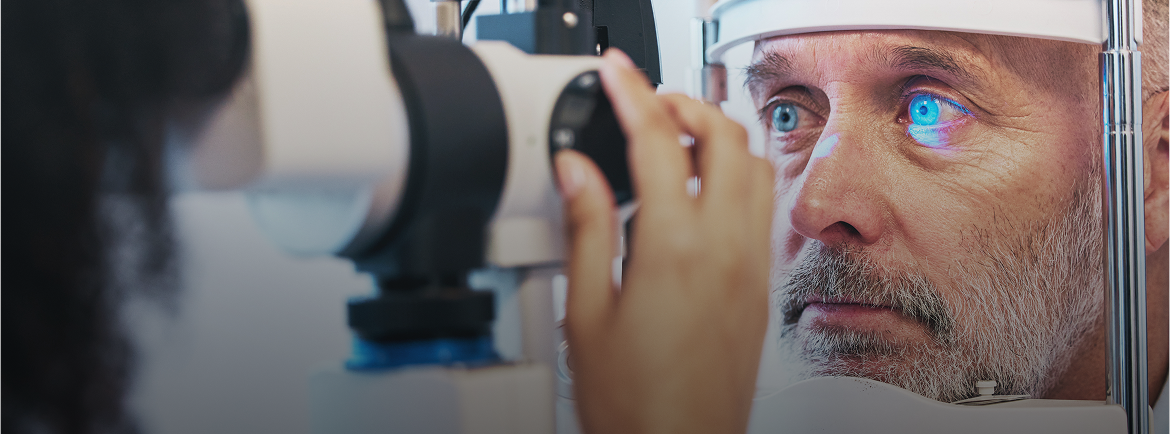 Older man undergoing an eye examination with a slit lamp